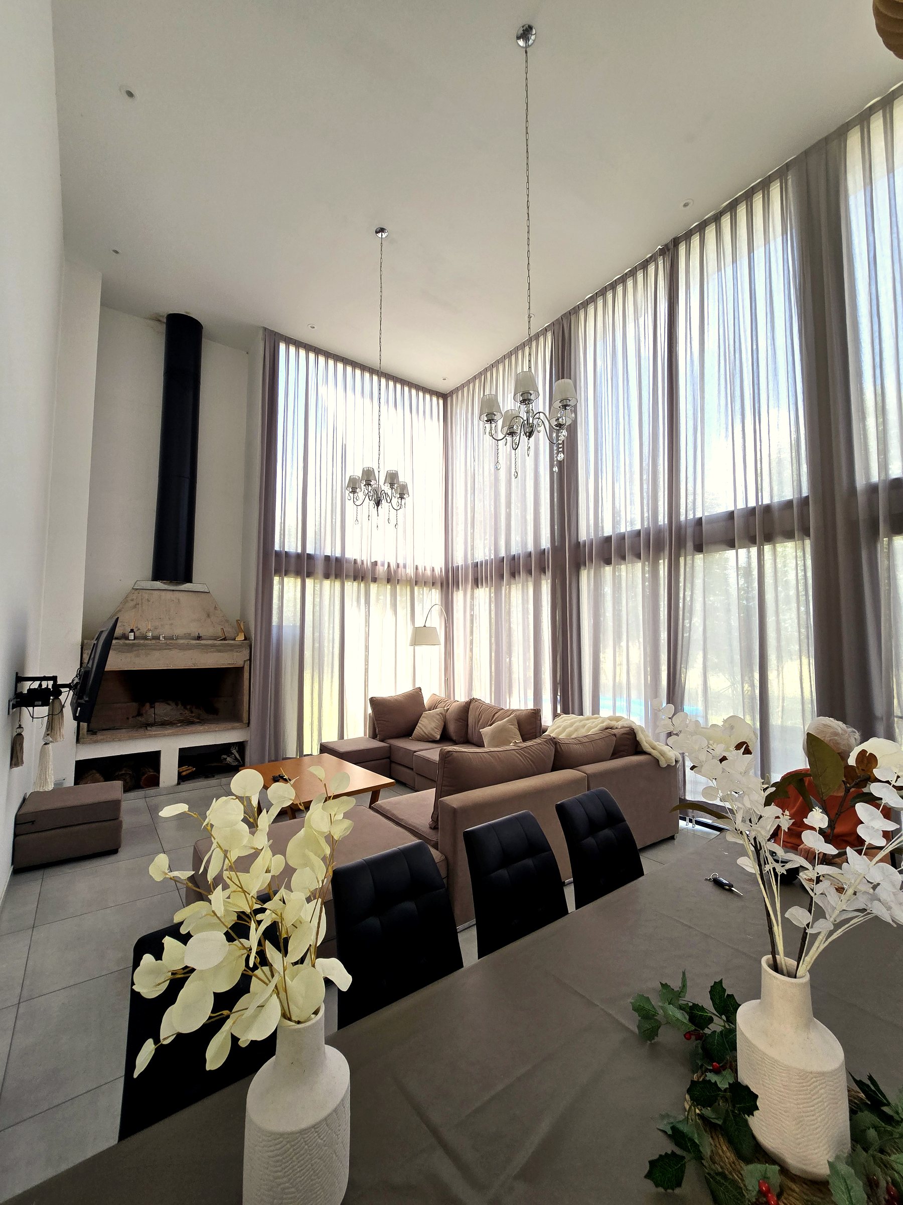 Cortinas tradicionales a medida en un living de doble altura